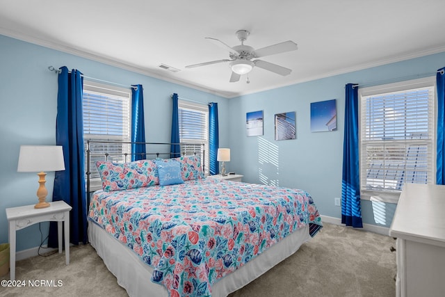 carpeted bedroom featuring ceiling fan and crown molding