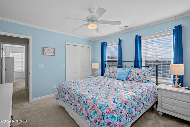 carpeted bedroom with a closet, crown molding, and ceiling fan