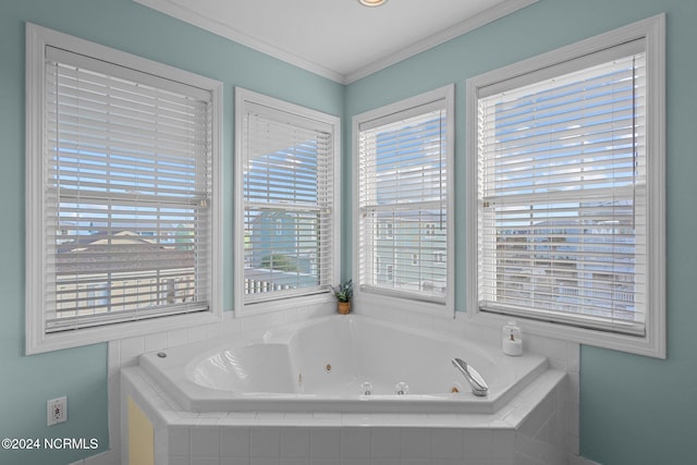 bathroom featuring a wealth of natural light, crown molding, and tiled bath