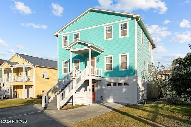 view of front of house with a front yard, a garage, and a porch