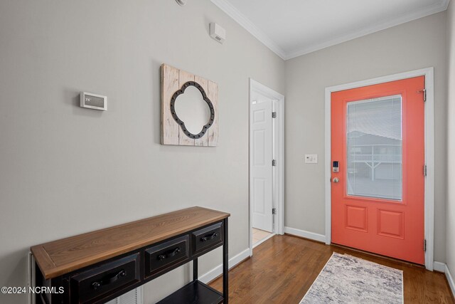 foyer with ornamental molding and dark hardwood / wood-style floors