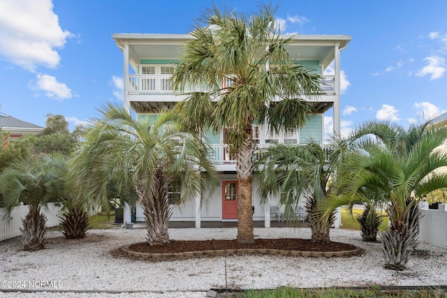 raised beach house featuring a balcony