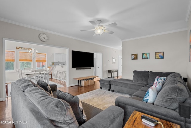 living room featuring dark wood-type flooring, crown molding, and ceiling fan with notable chandelier