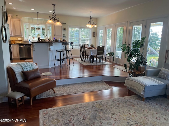 living room with dark hardwood / wood-style floors and an inviting chandelier