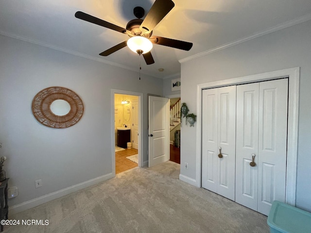 unfurnished bedroom featuring crown molding, light colored carpet, a closet, and ceiling fan