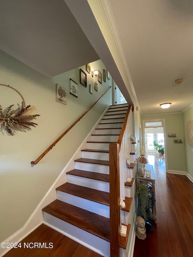 staircase with ornamental molding and hardwood / wood-style flooring