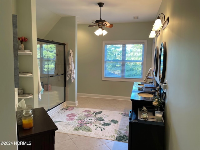 bathroom with a shower with shower door, ceiling fan, vaulted ceiling, vanity, and tile patterned flooring