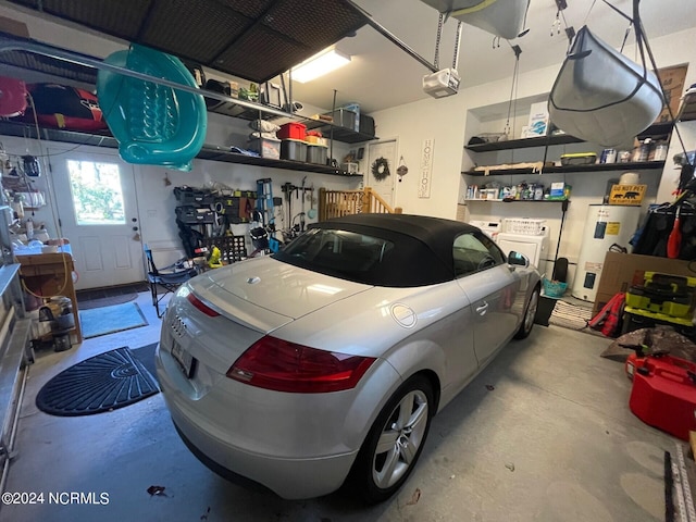 garage with a garage door opener, independent washer and dryer, and water heater