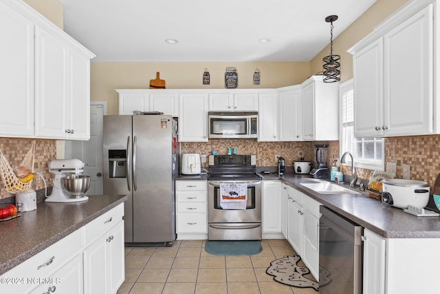 kitchen featuring white cabinetry, pendant lighting, appliances with stainless steel finishes, and sink