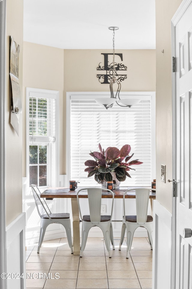 dining area with tile patterned flooring and a notable chandelier