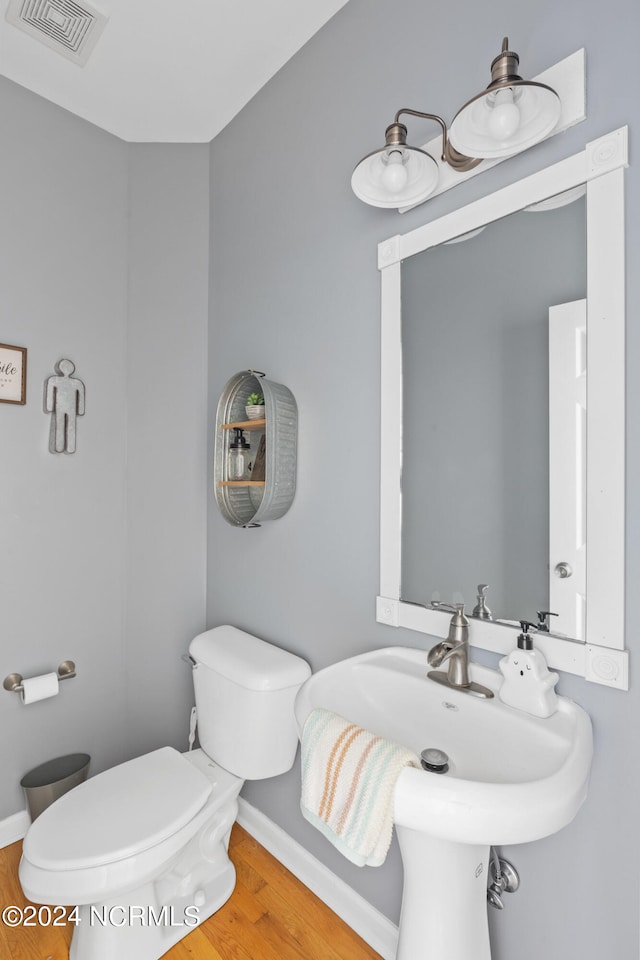 bathroom featuring hardwood / wood-style flooring and toilet