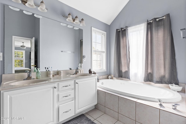 bathroom with tile patterned flooring, vanity, a healthy amount of sunlight, and vaulted ceiling