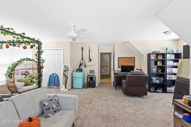 carpeted living room featuring ceiling fan and a textured ceiling