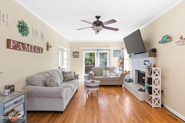 living room with a fireplace, wood-type flooring, ceiling fan, and crown molding