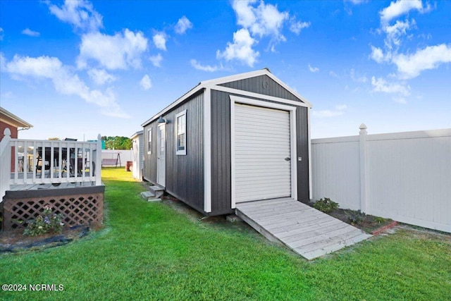 view of outdoor structure with a lawn and a garage