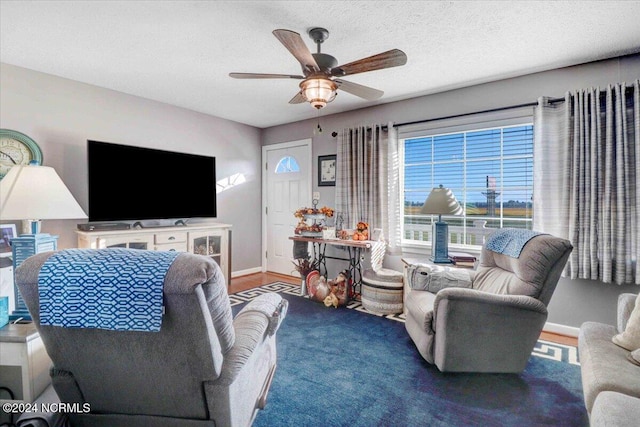 living room with a textured ceiling, hardwood / wood-style floors, and ceiling fan