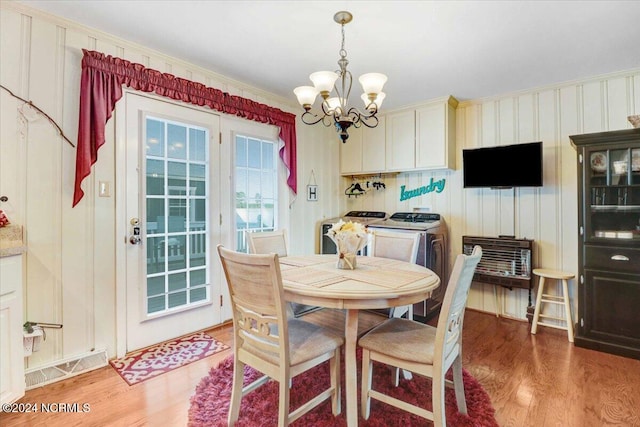 dining space with crown molding, wood-type flooring, separate washer and dryer, and a chandelier