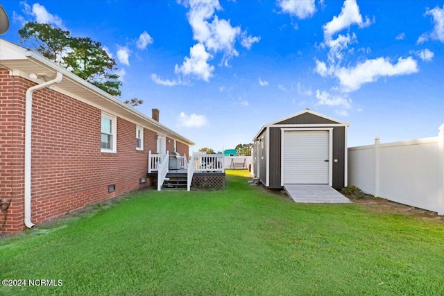 view of yard featuring a wooden deck and a storage unit