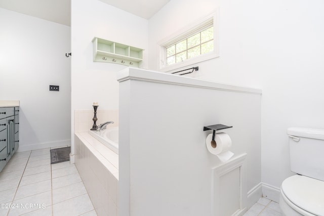 bathroom with toilet, vanity, tiled tub, and tile patterned floors