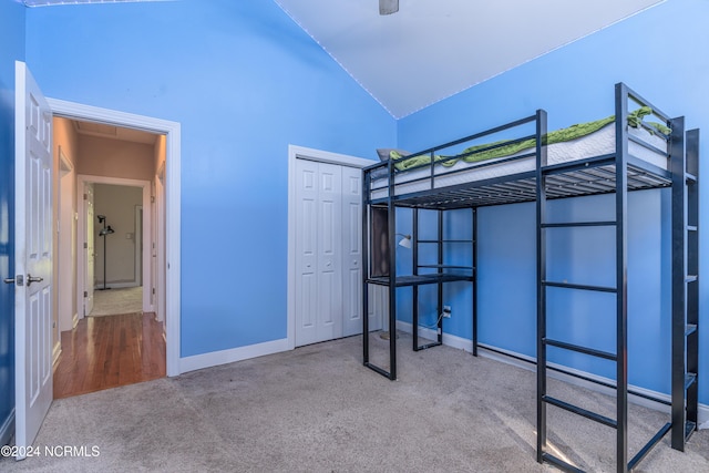 unfurnished bedroom with a closet, high vaulted ceiling, and carpet flooring