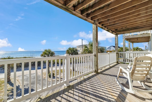 deck featuring a water view and a beach view