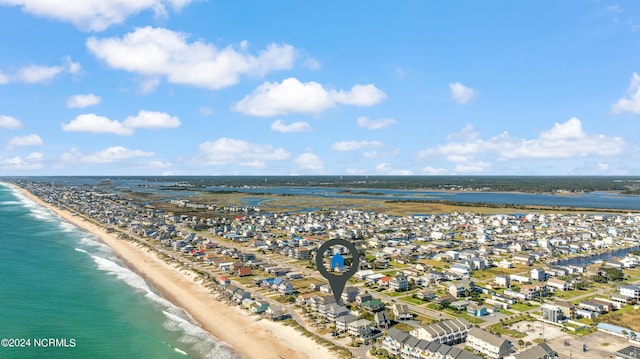 birds eye view of property with a water view and a beach view