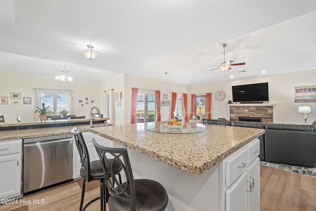 kitchen with white cabinetry, a healthy amount of sunlight, light hardwood / wood-style flooring, and stainless steel dishwasher