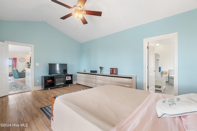 bedroom featuring ensuite bath, vaulted ceiling, light wood-type flooring, and ceiling fan