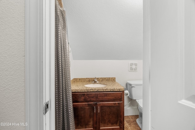 bathroom with toilet, vanity, and tile patterned flooring