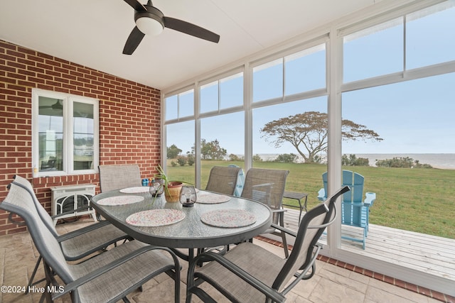 sunroom / solarium with a water view and ceiling fan