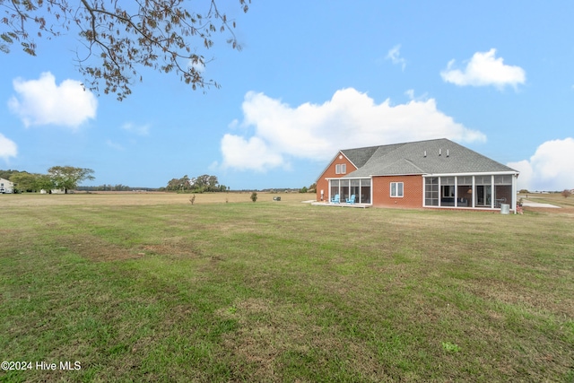 view of yard featuring a rural view and a sunroom