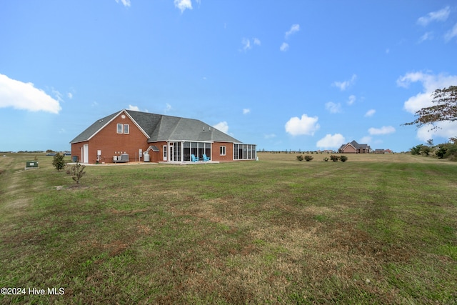 rear view of property featuring a yard and a rural view