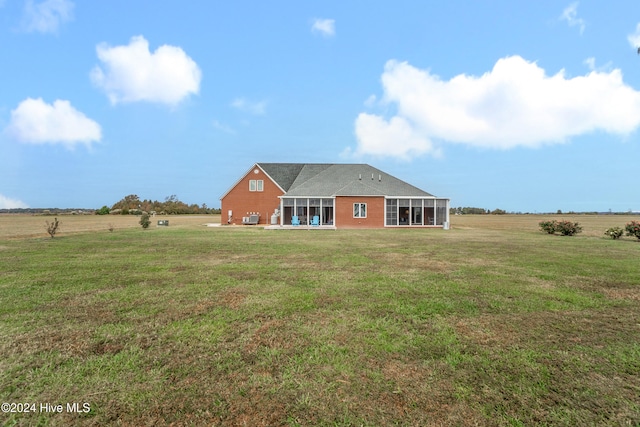 back of house with a rural view and a yard