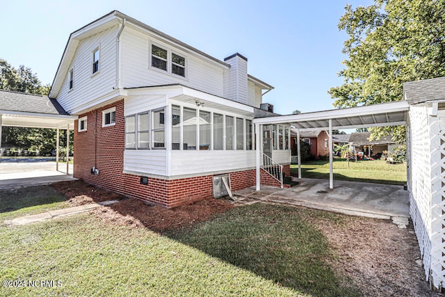 back of property featuring a lawn and a sunroom