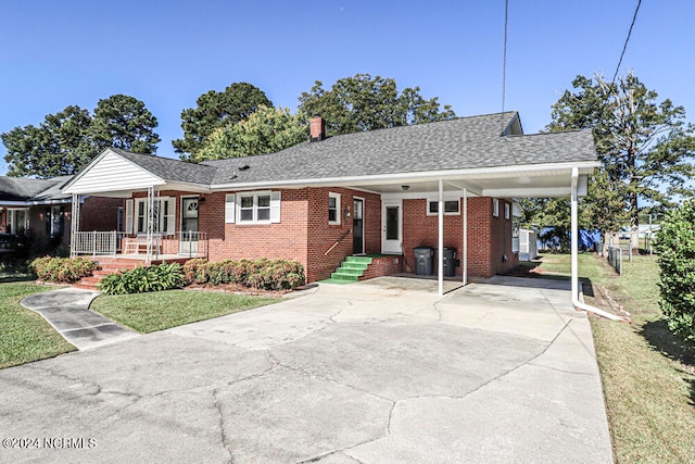 view of front of property featuring covered porch, a front lawn, and a carport