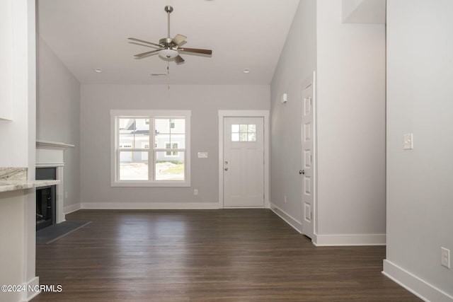 unfurnished living room featuring ceiling fan, lofted ceiling, and dark hardwood / wood-style flooring