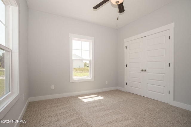 unfurnished bedroom with a closet, ceiling fan, and carpet floors