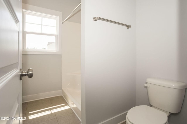 bathroom featuring toilet, tile patterned floors, and a shower