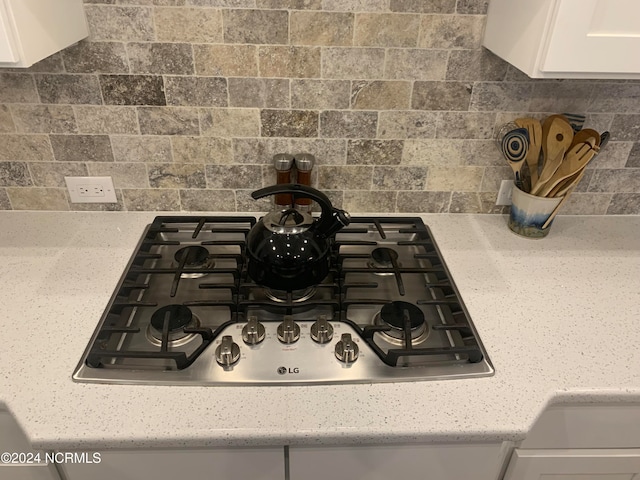 kitchen with a spacious island, dark hardwood / wood-style floors, wall chimney exhaust hood, white cabinetry, and appliances with stainless steel finishes