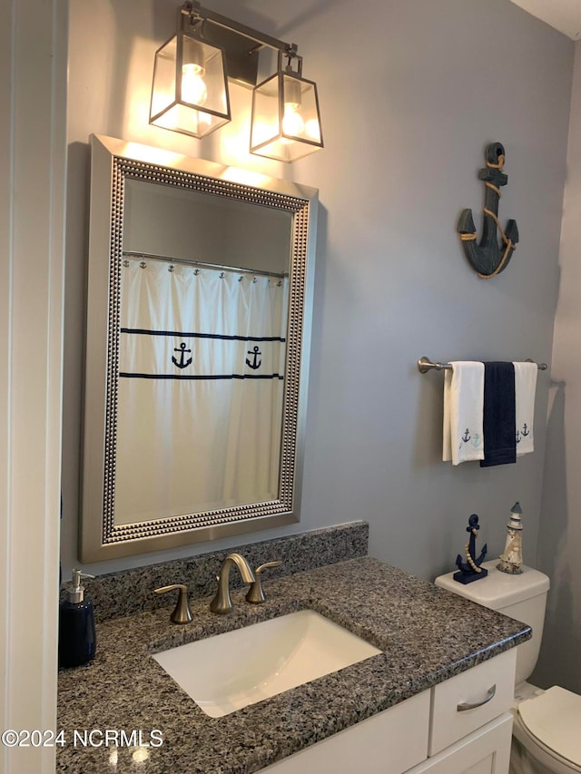 bathroom with vanity, curtained shower, and toilet