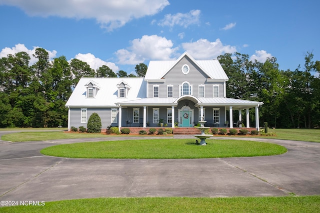 farmhouse-style home featuring a porch and a front lawn