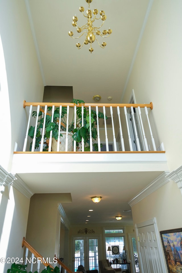 interior details featuring ornamental molding, french doors, and an inviting chandelier