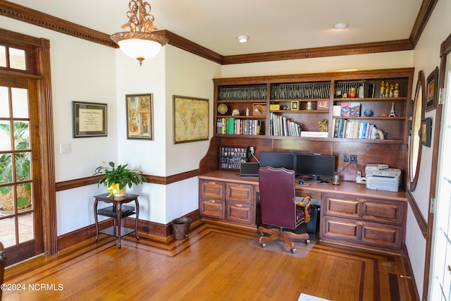 office with built in desk, crown molding, and light hardwood / wood-style floors