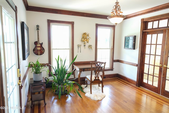 interior space featuring ornamental molding, hardwood / wood-style floors, a notable chandelier, and french doors