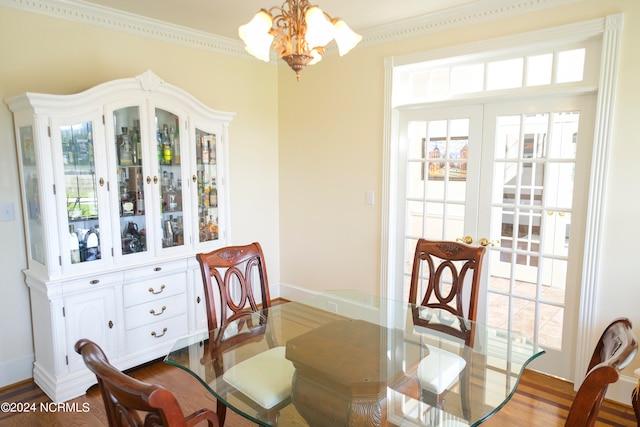 dining space with crown molding, a chandelier, and hardwood / wood-style floors