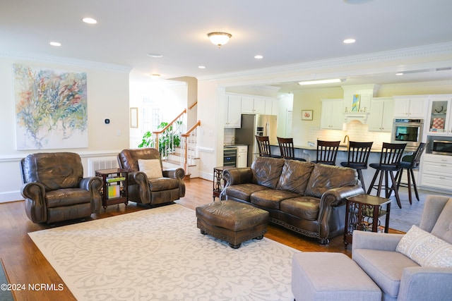 living room featuring wine cooler, crown molding, and hardwood / wood-style flooring