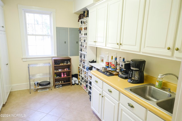 kitchen with sink, white cabinetry, and light tile patterned floors