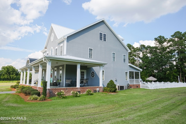 exterior space featuring a porch, cooling unit, and a yard