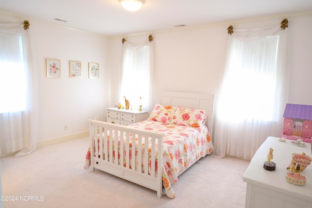 bedroom with ornamental molding, light carpet, and multiple windows