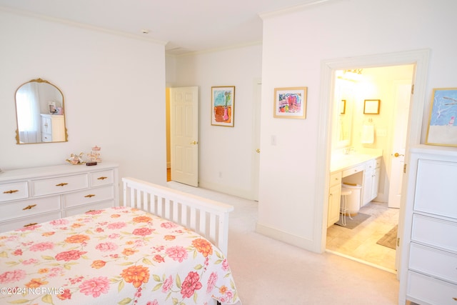 bedroom with crown molding, light colored carpet, and ensuite bath